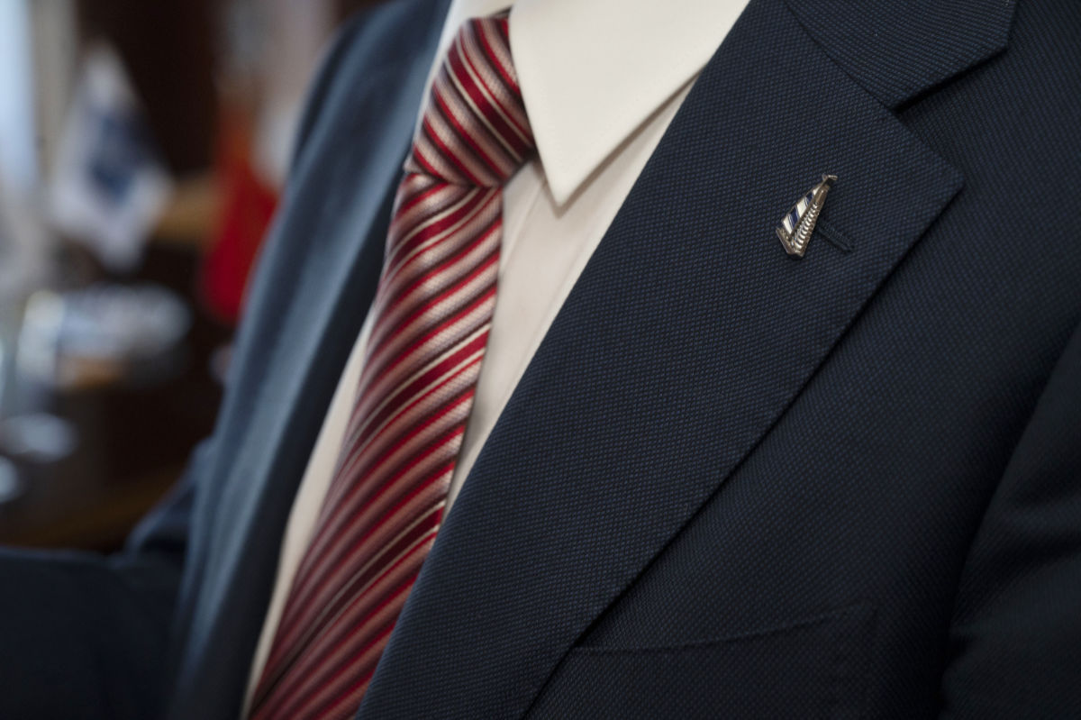 man in suit with a pin in the shape of a ship