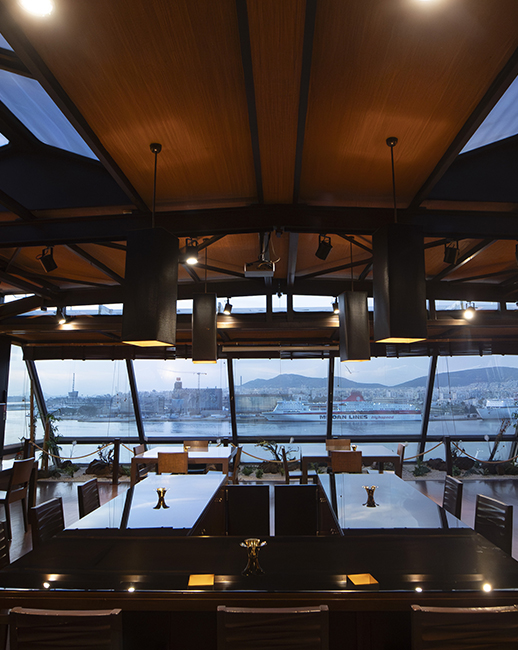 dinning hall with wooden tables and floors with views of the Piraeus port